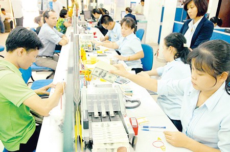 Customers conduct transactions at a bank in Ho Chi Minh City.